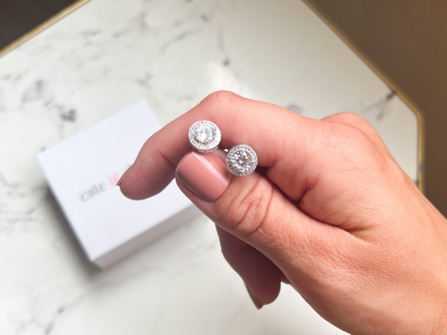 hand holding stud earrings