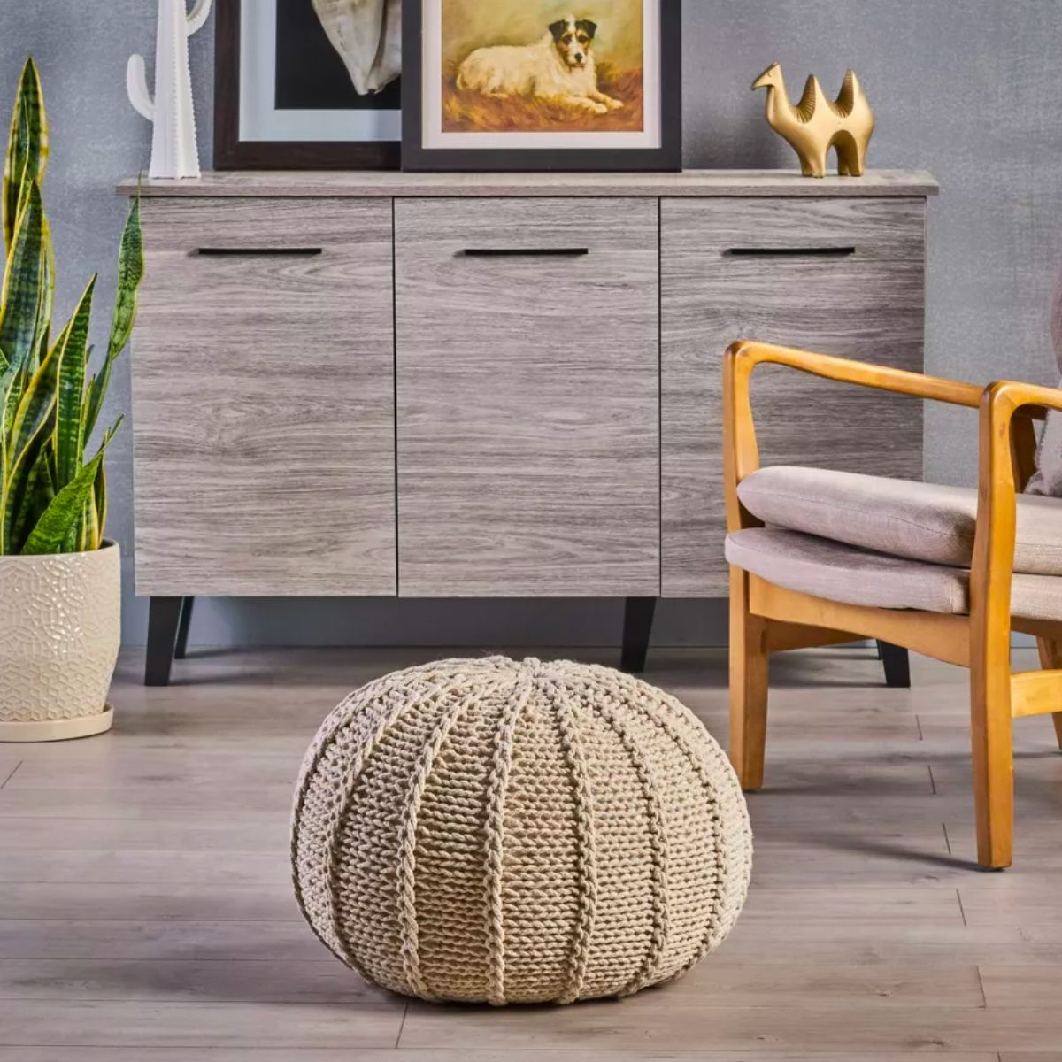 Christopher Knight Home Corisande Knitted Cotton Pouf in front of a credenza and wood frame chair