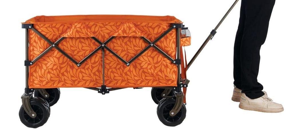 A person pulling a Collapsible Beach Wagon Orange