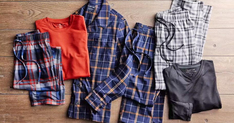 folded men's pajama items on wood floor