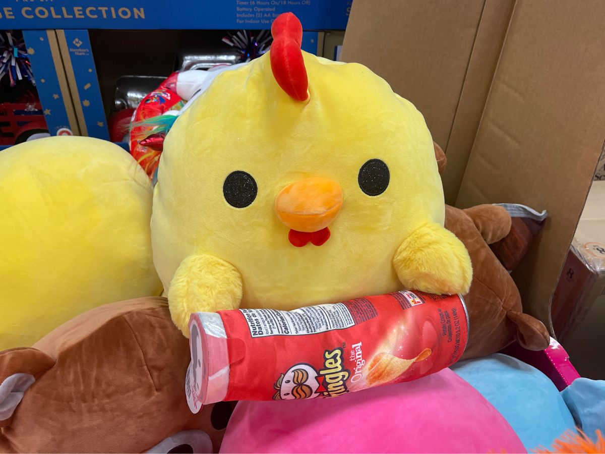 A chicken plush toy holding a can of Pringles