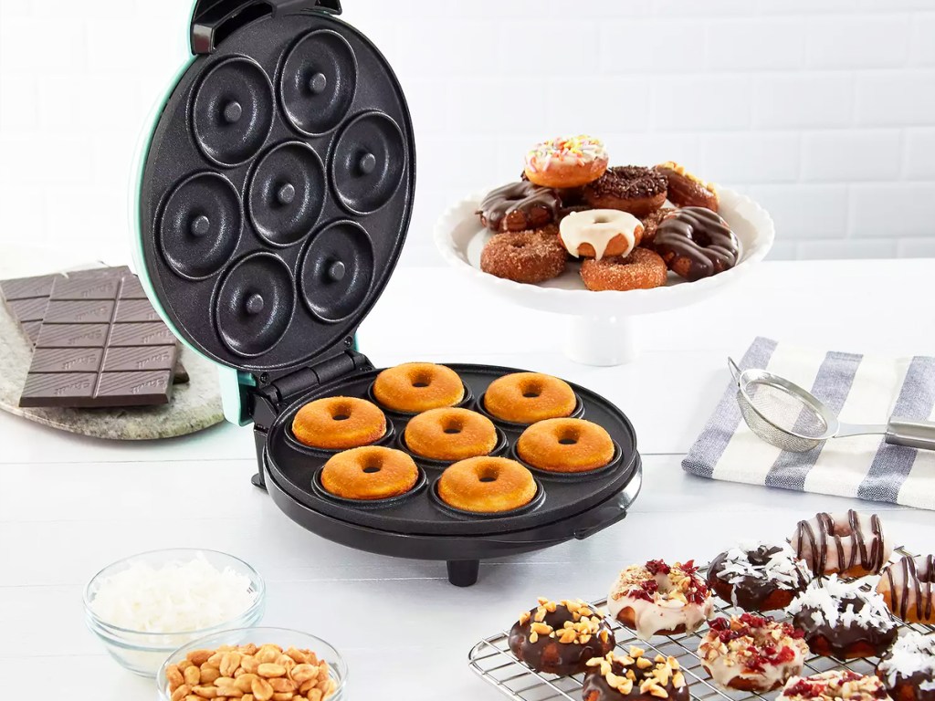 donut maker on counter with various decorated treats