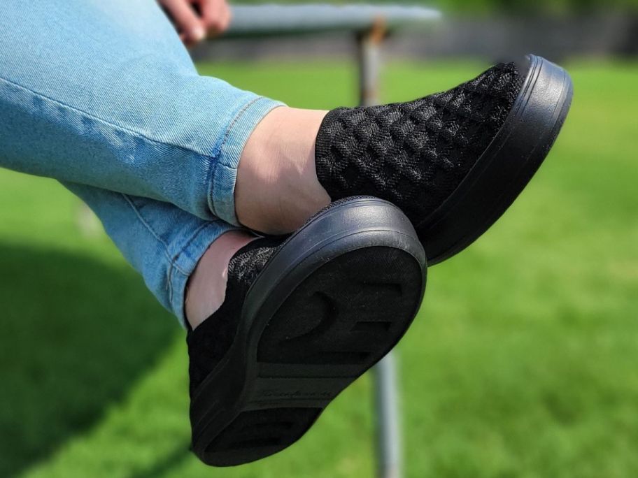woman's feet wearing Dearfoams slip on sneakers
