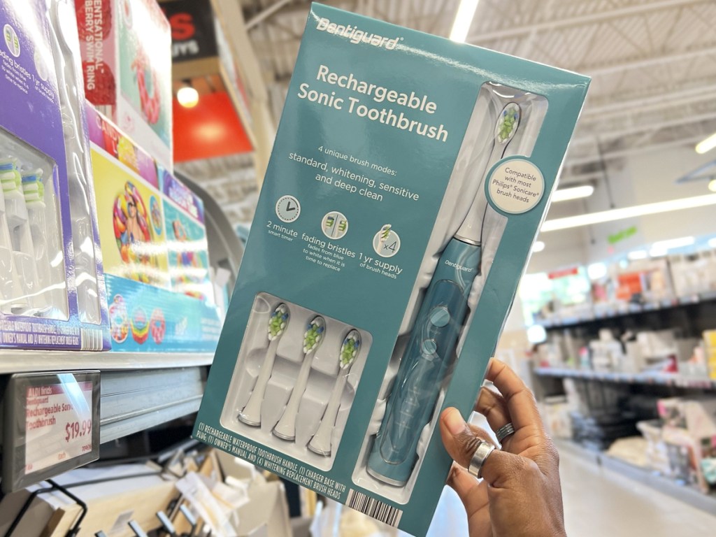 hand grabbing electric toothbrush box from store shelf