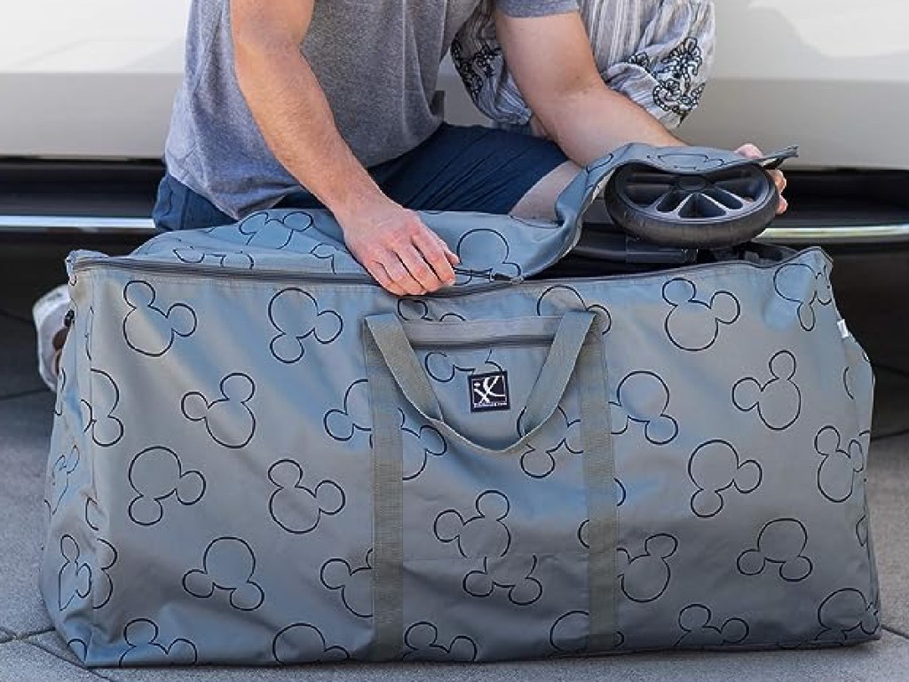 Disney stroller bag in gray being packed by man