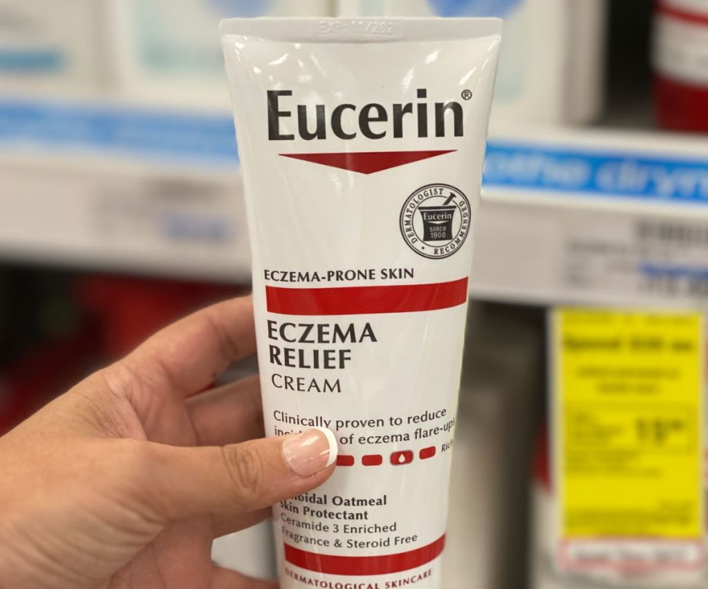 a womans hand holding a tube of Eucerin eczema relief 5oz