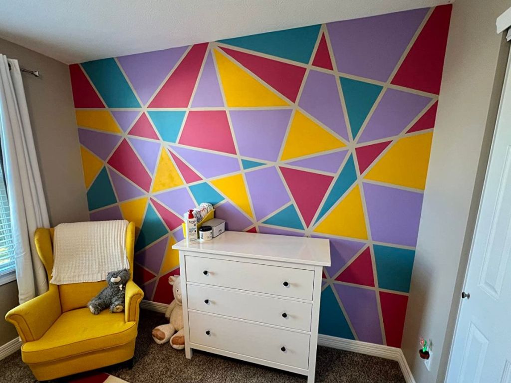 A bedroom with a very elaborate colorful geo wall 
