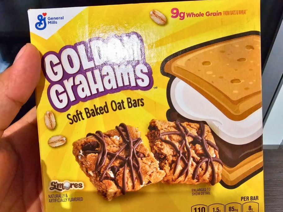Hand holding a box of Golden Grahams Bars