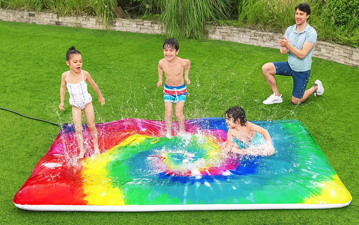 family playing on rainbow splash pad