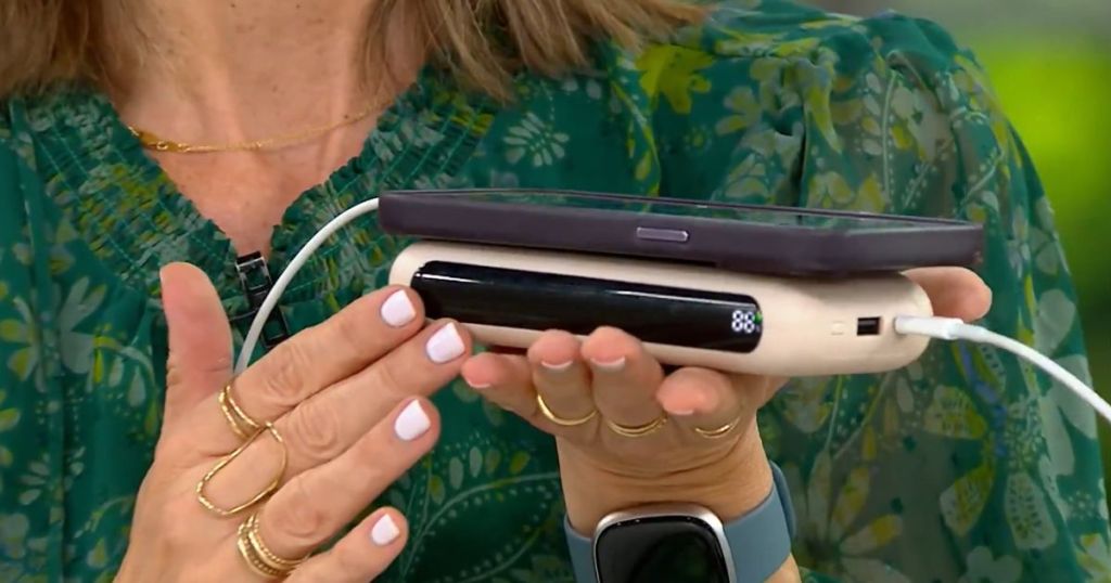 woman holding sand charging power bank with phone on top