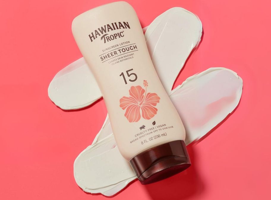 a bottle of spf 15 sunscreen on a pink background