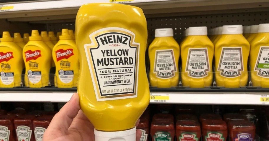hand holding a bottle of Heinz yellow mustard in a store