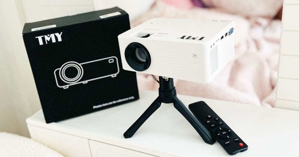 TMY Mini Projector with Tripod shown set up and with box in living room