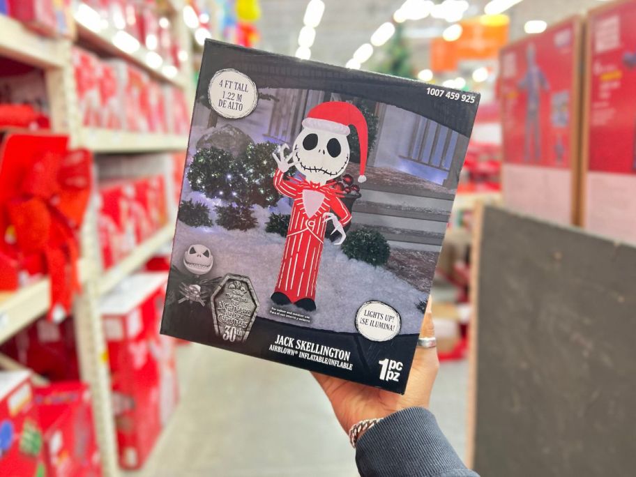 A hand holding a box with a Home Depot Jack Skellington Inflatable