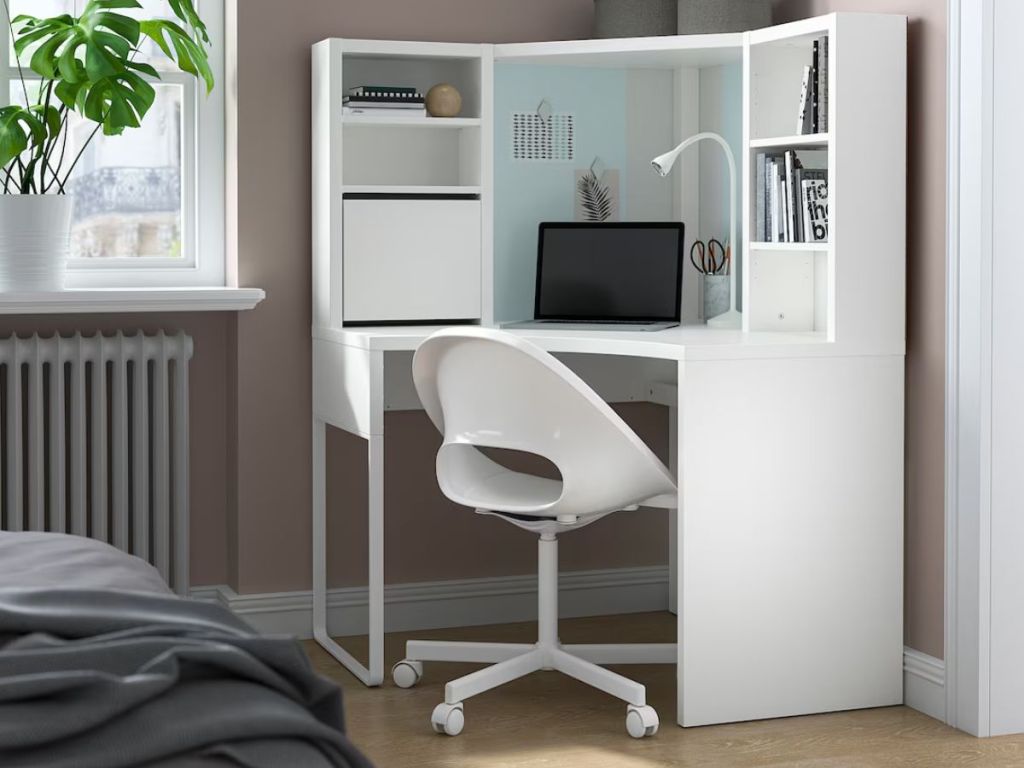 white corner desk with shelving and chair in room