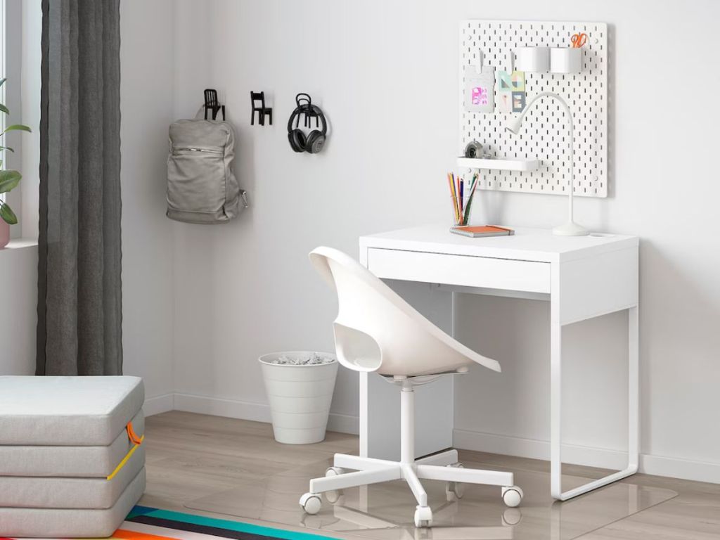 smaller white desk with white chair in room