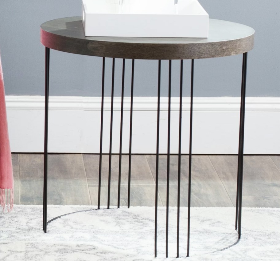 round side table with black metal legs and brown top