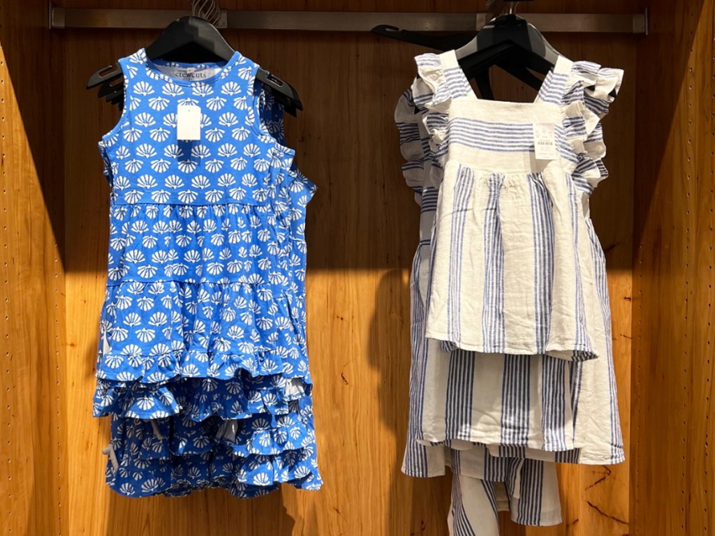 blue and white dresses hanging in store
