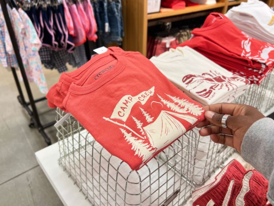 woman holding J.crew t-shirt at the store