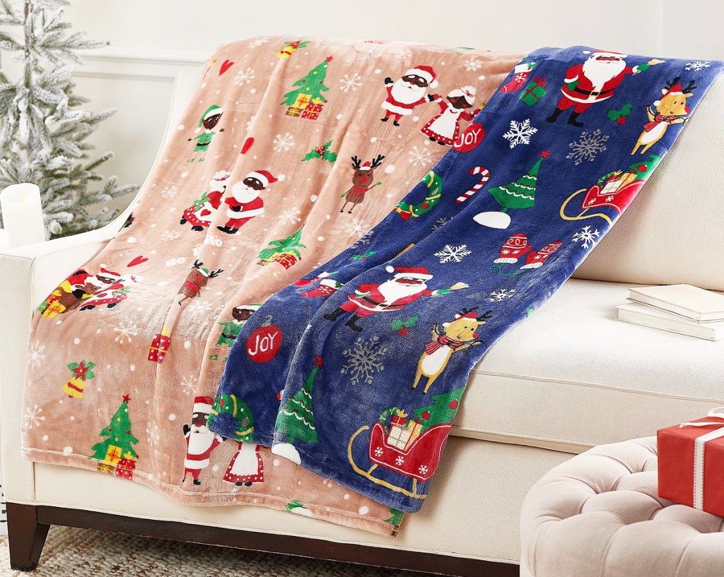 two christmas print throw blankets draped over a couch