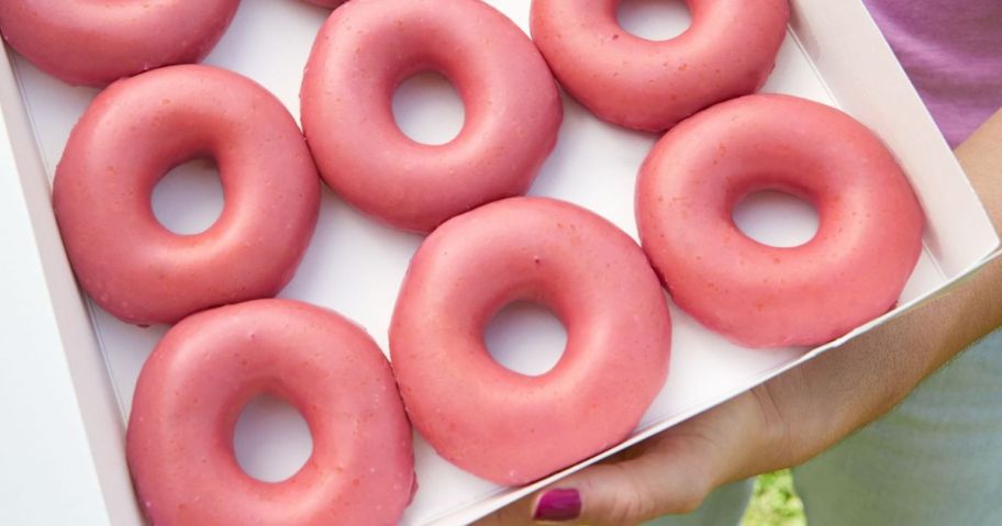 Hand holding a box of Krispy Kreme Strawberry Glazed Boughnuts