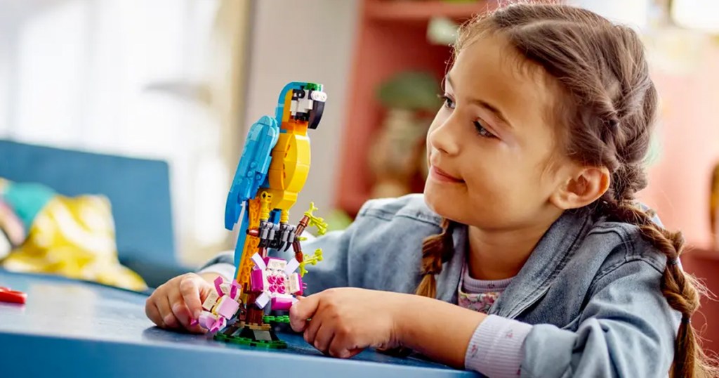 girl playing with lego parrot set