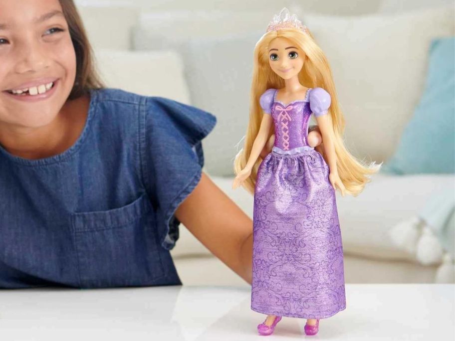 A girl playing with Mattel Disney Princess Dolls, Rapunzel Posable Fashion Doll