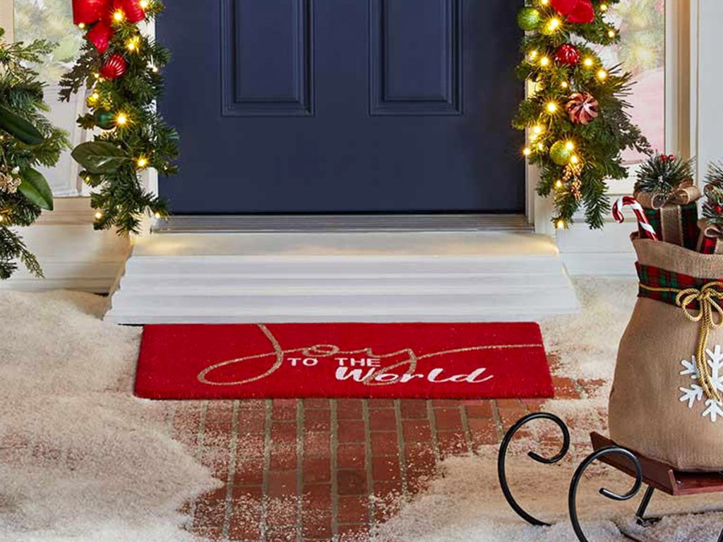 front door with red doormat that says joy to the world