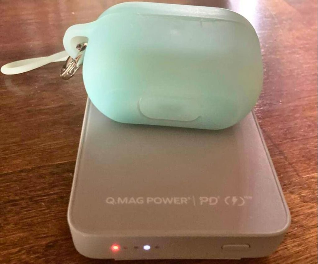 A momax charger with AirPods charging on it