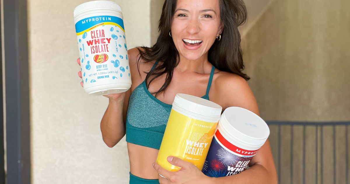 Woman holding 3 containers of MyProtein Clear Whey Isolate
