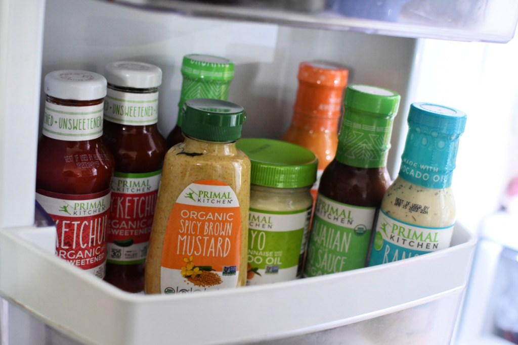 A refrigerator with Primal Kitchen condiments inside