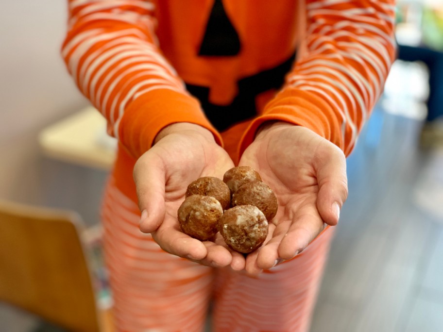 Person holding Pumpkin Munchkins at Dunkin' Donuts