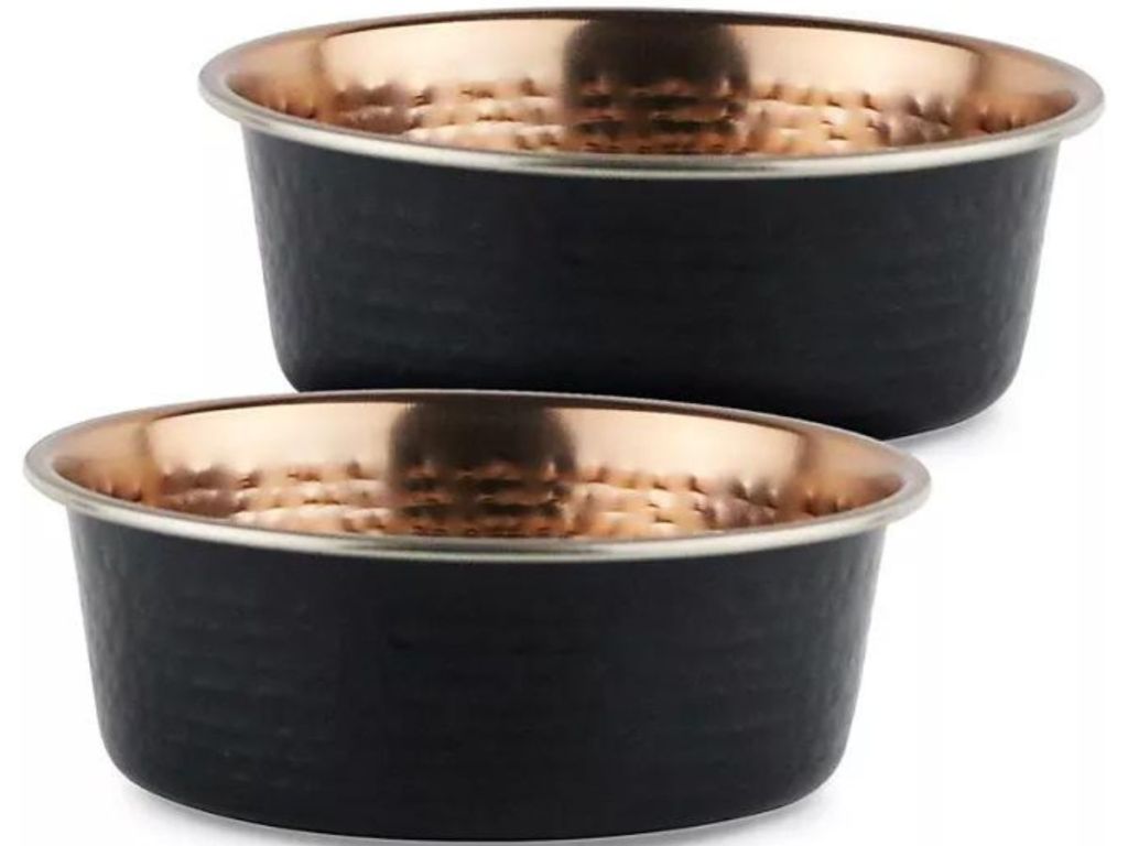 Stock image of 2 matte black dog bowls with a hammered copper interior