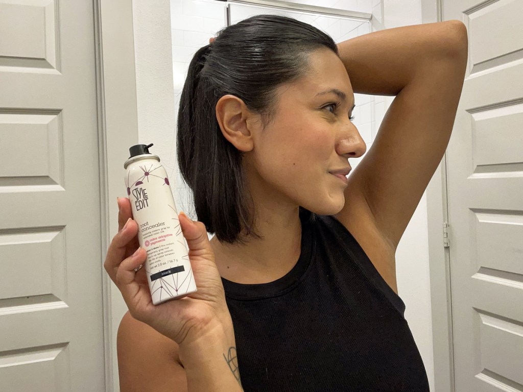 woman holding up a bottle of root touch up spray