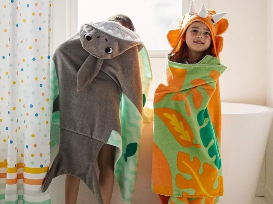 Two kids wearing The Big One Hooded Bath Towels in the bathrom