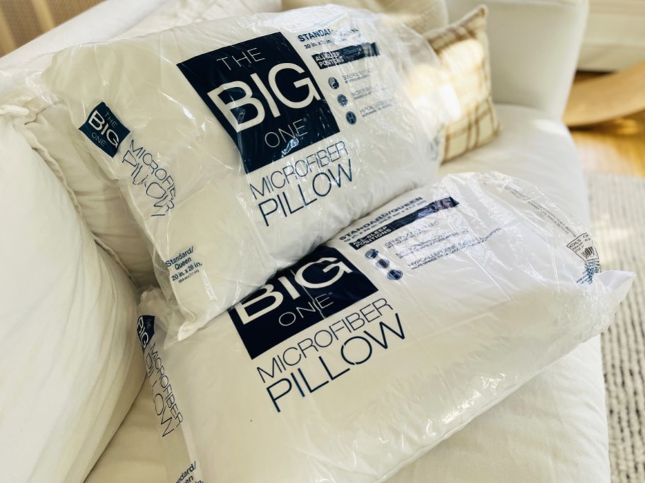 two big one bed pillows on white couch