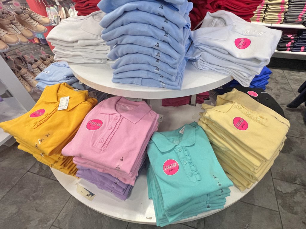 round display table full of folded girls polo shirts