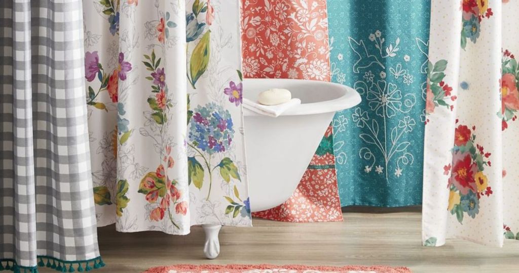 A claw-foot bathtub surrounded by various patterns of Pioneer Woman curtains 