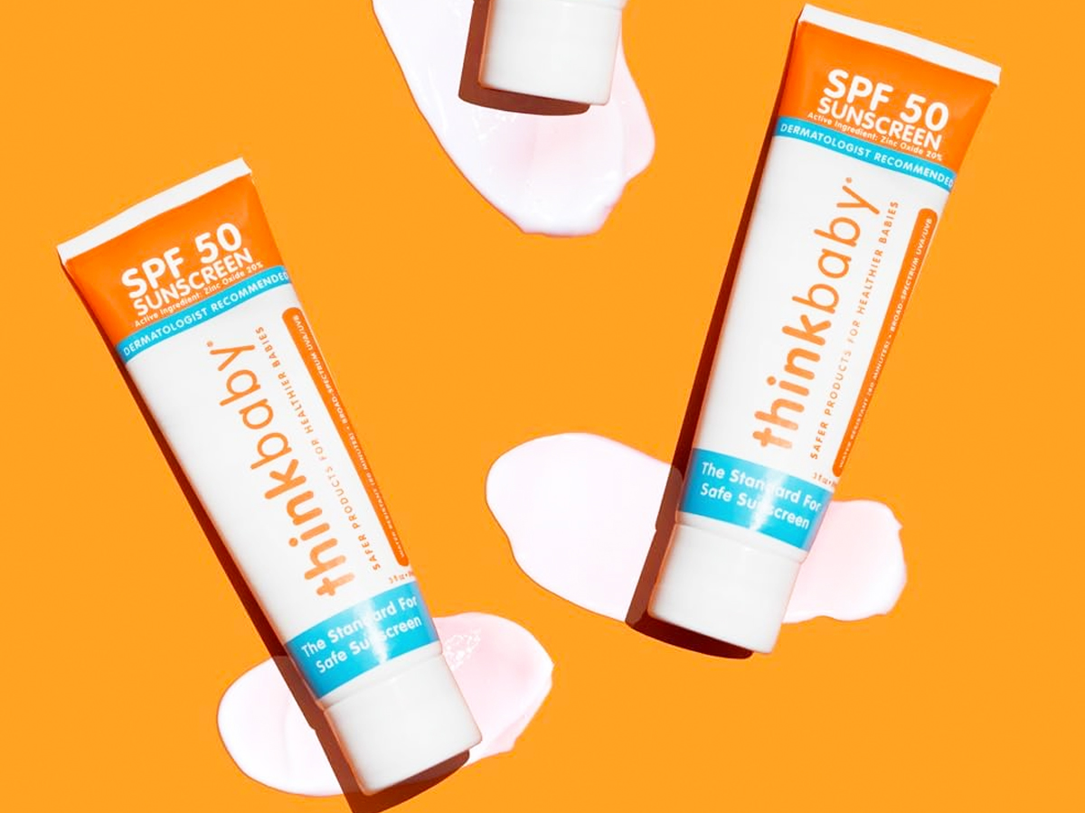 two tubes of thinkbaby sunscreen on orange background