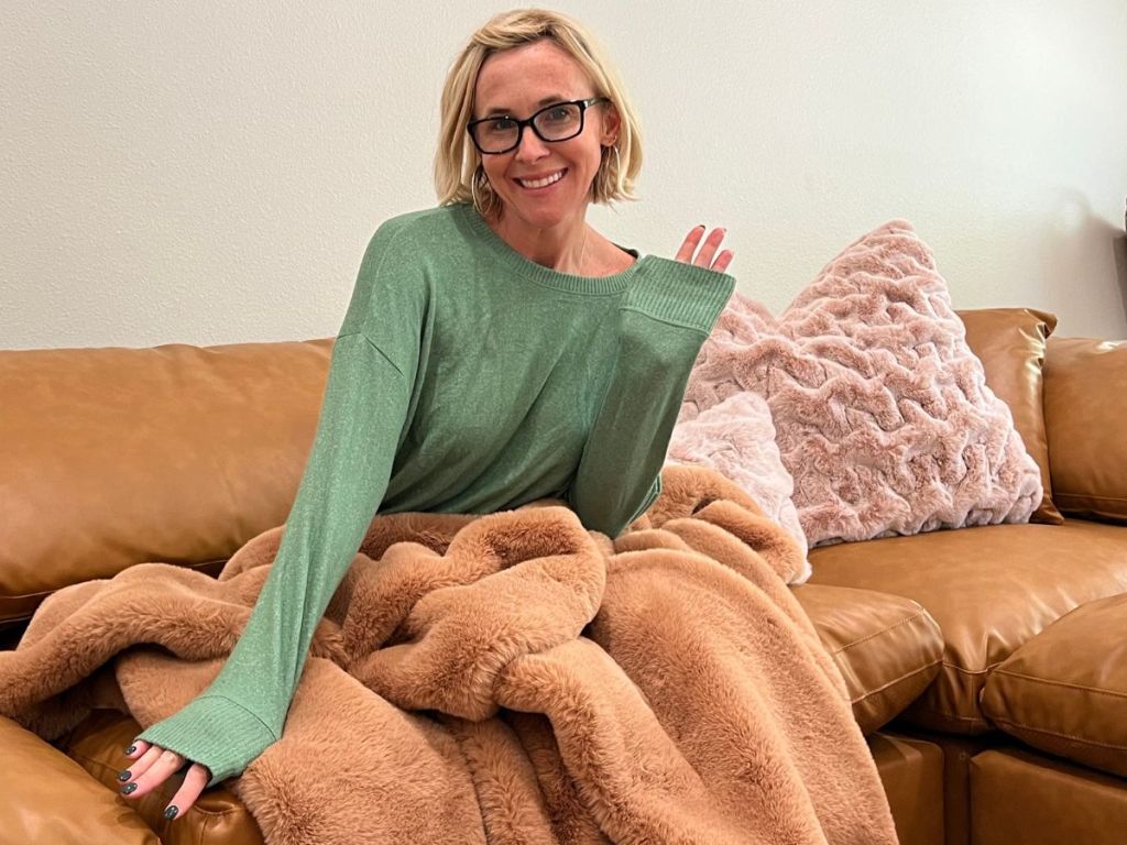 A woman sitting on a couch with a green shirt on 