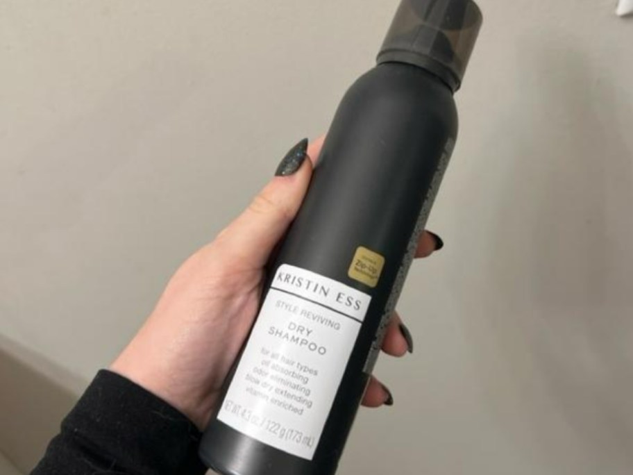 hand holding a black bottle of Kristin Ess Hair Style Reviving Dry Shampoo