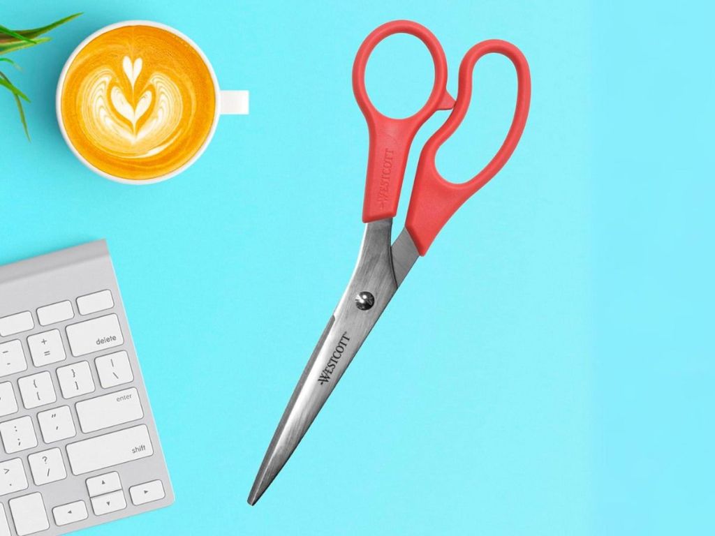 Westcott 8 All Purpose Value Straight Scissors with Red Handles next to a keyboard and a cup of cappuccino 