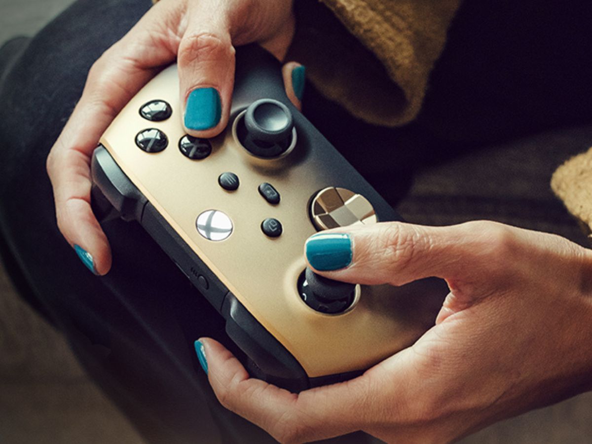 A person playing with an XBox Wireless Controller in Gold
