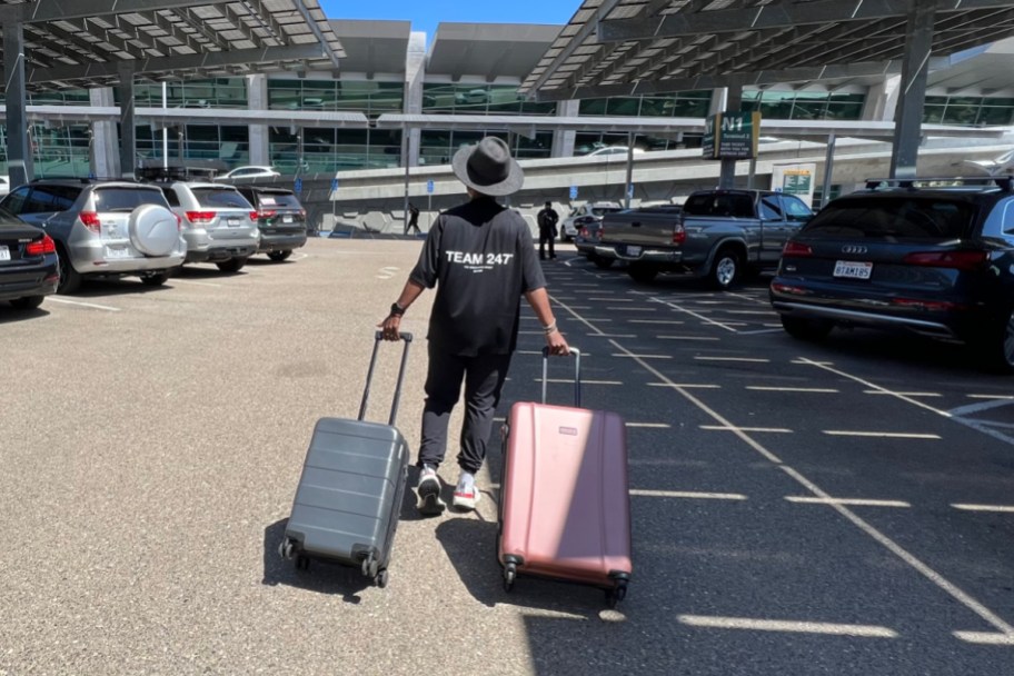 woman walking with luggage in parking lot