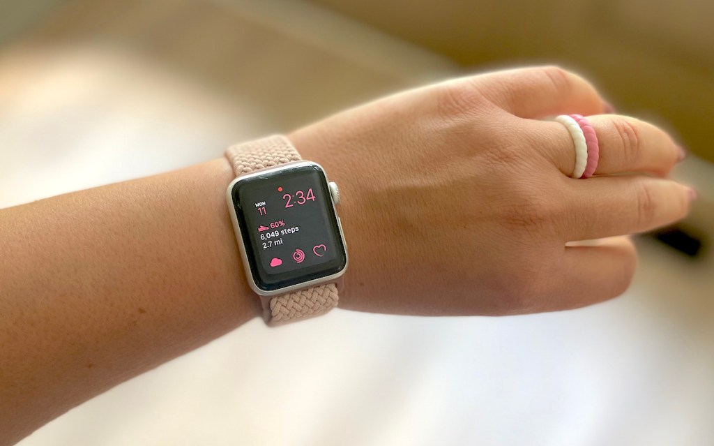 arm with apple watch and silicone rings on finger