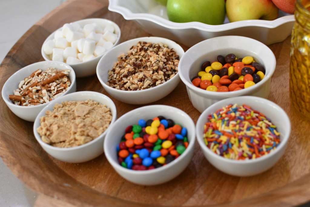 assorted toppings for a caramel apple board