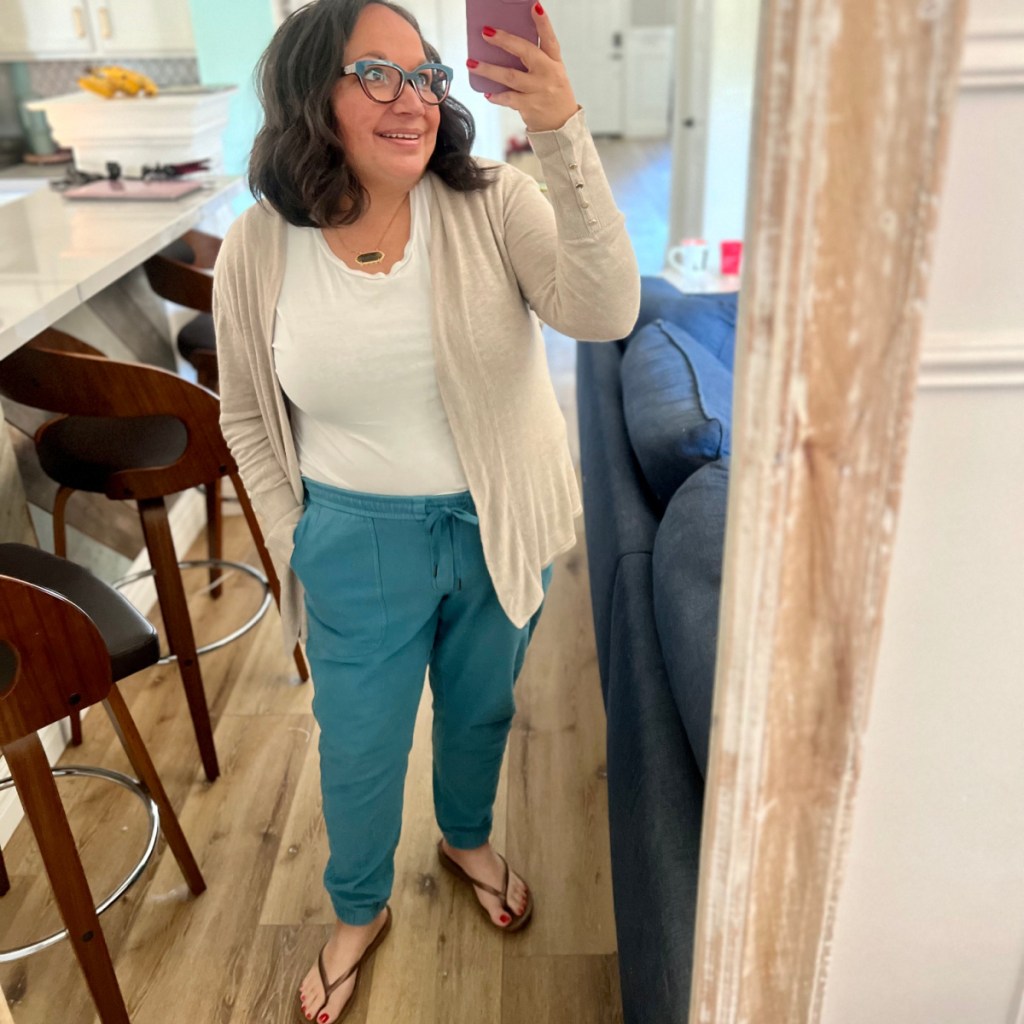 woman holding iphone in mirror wearing joggers