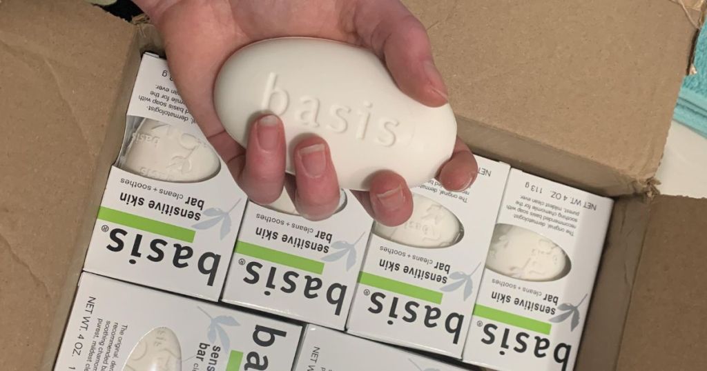 hand holding Basis bar soap above box of soaps