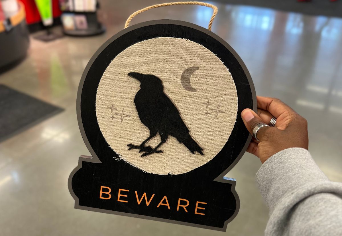 black crow hanging beware sign