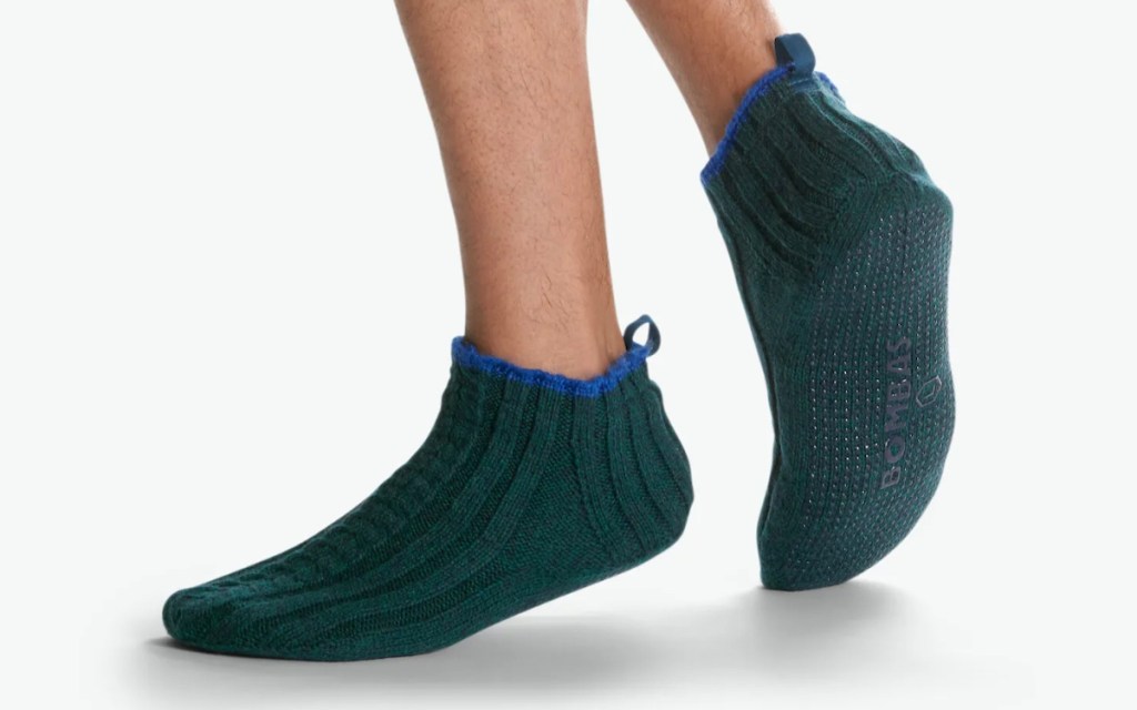 stock photo of mans feet wearing green cable knit bombas grippy slippers